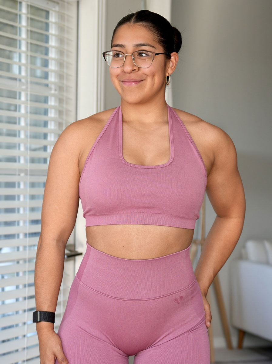 The coach smiling in pink workout clothes.